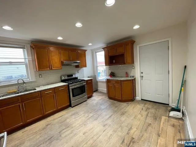 a kitchen with stainless steel appliances granite countertop a sink and a stove top oven