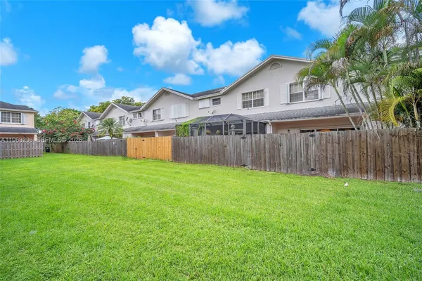 a view of a house with backyard and a garden
