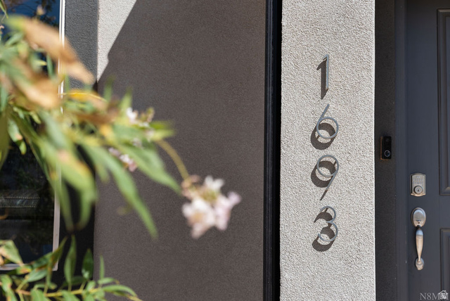 1693 Devils Gdn Lane Washington, UT 84780 - Photo 36 of 64 Contemporary exterior featuring stucco siding, vertical house numbers, and a dark entry door with modern hardware