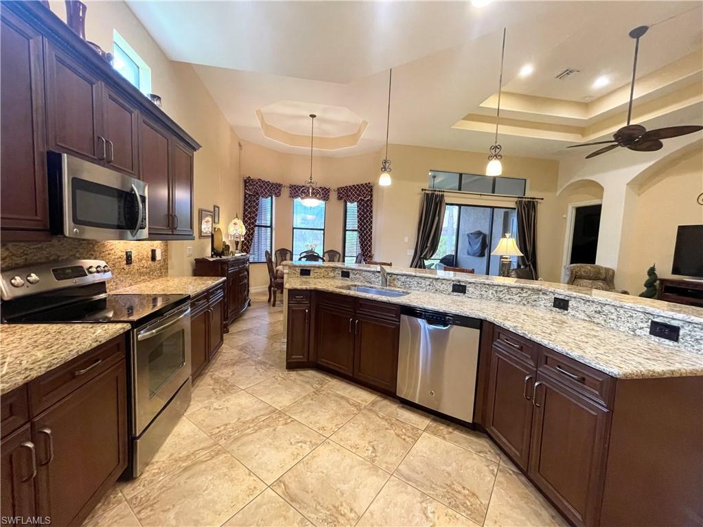 7302 Acorn Way Naples, FL 34119 - Photo 12 of 40 a large kitchen with a large counter top appliances and cabinets