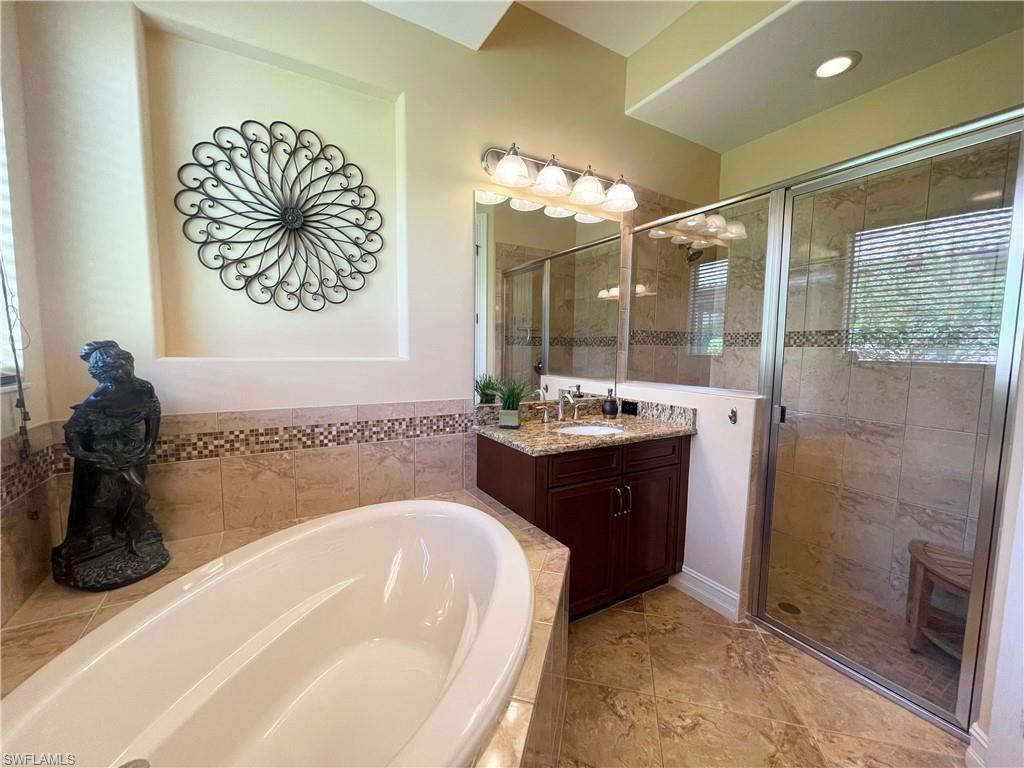 7302 Acorn Way Naples, FL 34119 - Photo 21 of 40 a bathroom with a tub sink and mirror