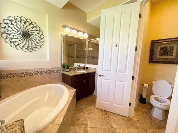 a spacious bathroom with a granite countertop sink and a mirror