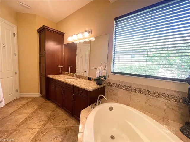a bathroom with a tub sink and mirror