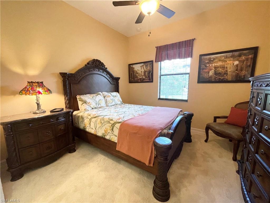 7302 Acorn Way Naples, FL 34119 - Photo 27 of 40 a bedroom with a bed and a chandelier