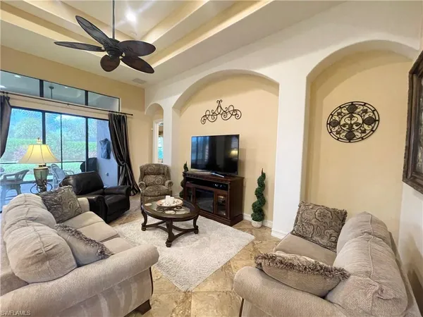 a living room with furniture a flat screen tv and a large window