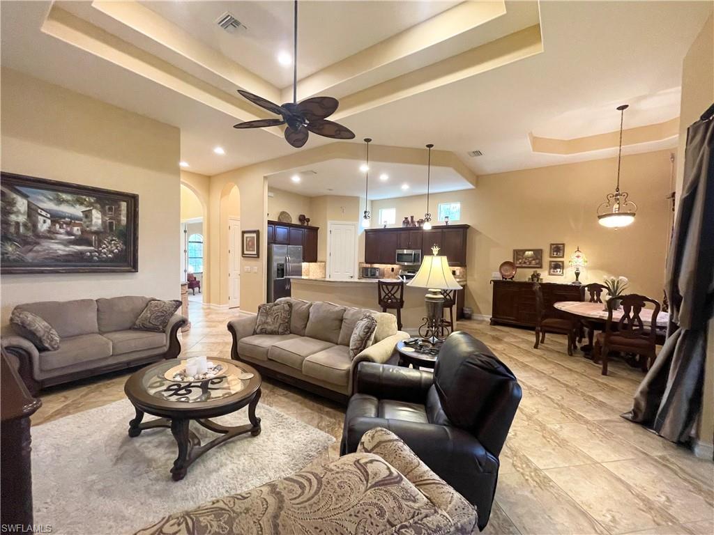 7302 Acorn Way Naples, FL 34119 - Photo 8 of 40 a living room with furniture and a chandelier
