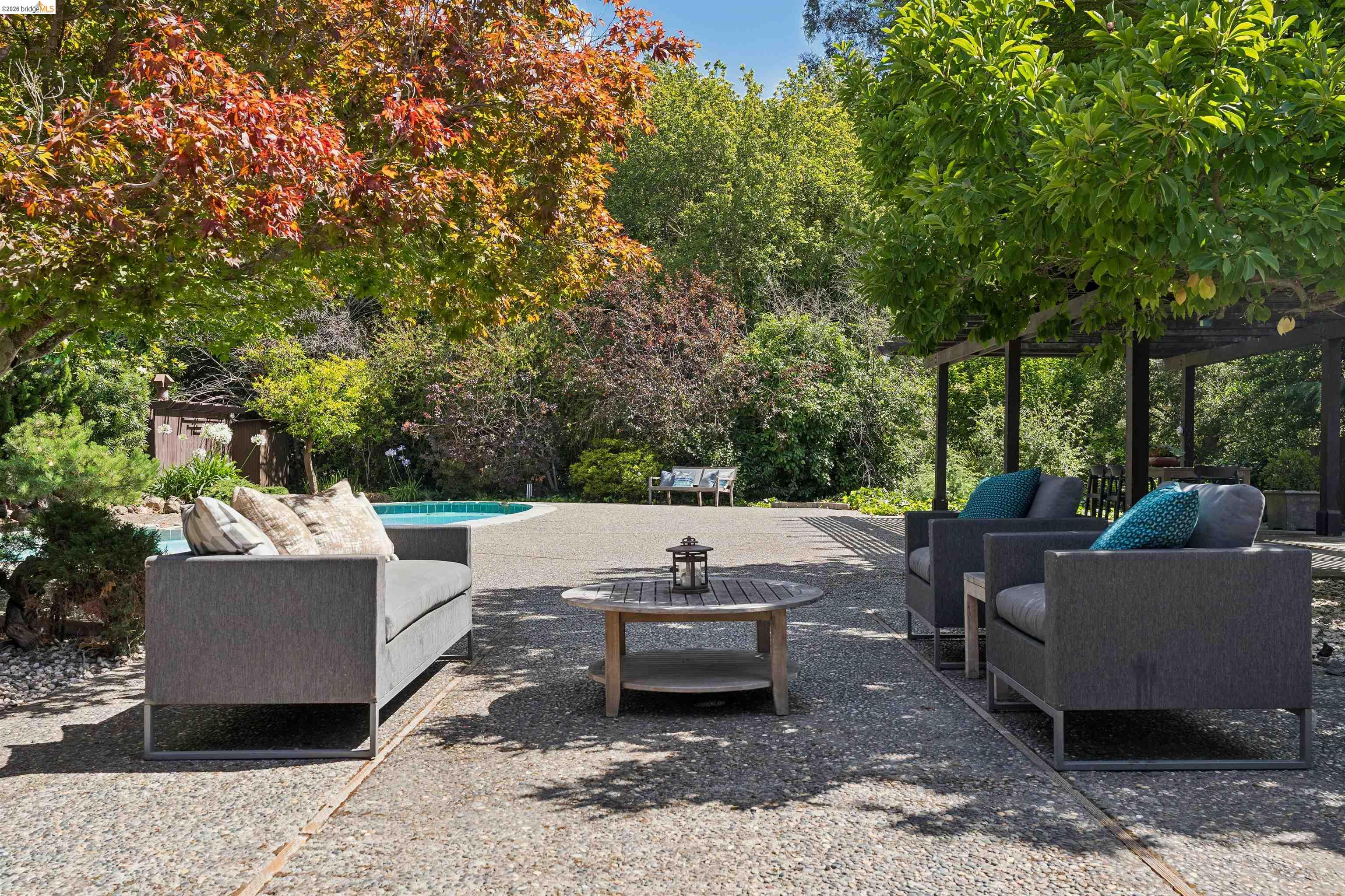 7 Jo Lin Court El Sobrante, CA 94803 - Photo 82 of 99 Expansive stone patio featuring a perimeter swimming pool and diverse mature landscaping