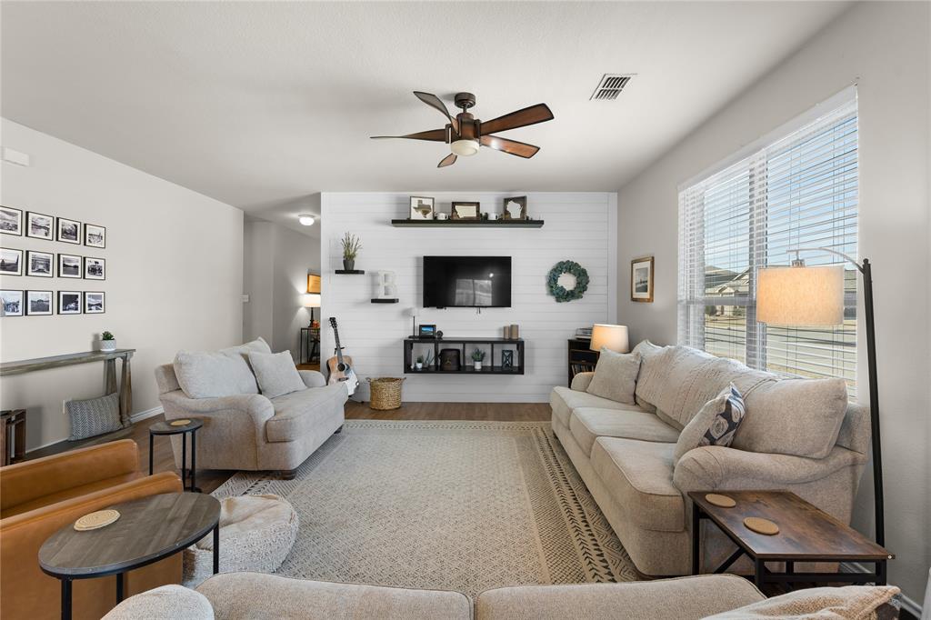 1061 Stanridge Lane Van Alstyne, TX 75495 - Photo 15 of 37 a living room with furniture a fireplace and a large window