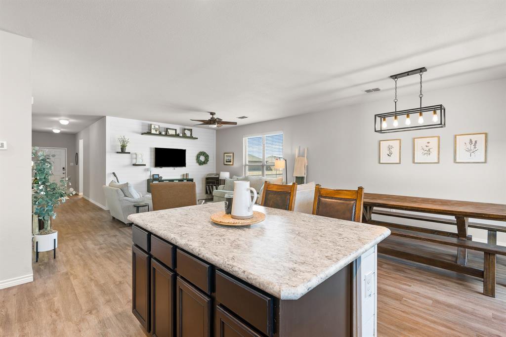 1061 Stanridge Lane Van Alstyne, TX 75495 - Photo 20 of 37 a kitchen with a table chairs and a refrigerator
