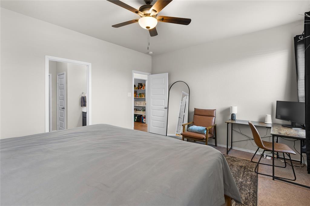 1061 Stanridge Lane Van Alstyne, TX 75495 - Photo 24 of 37 a bedroom with a bed and a chandelier