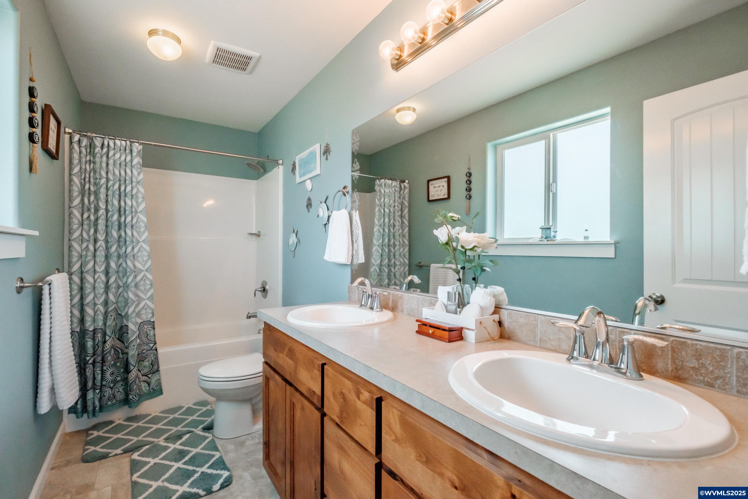 12433 Summit Loop Road Southeast Turner, OR 97392 - Photo 22 of 41 a bathroom with a double vanity sink toilet and shower