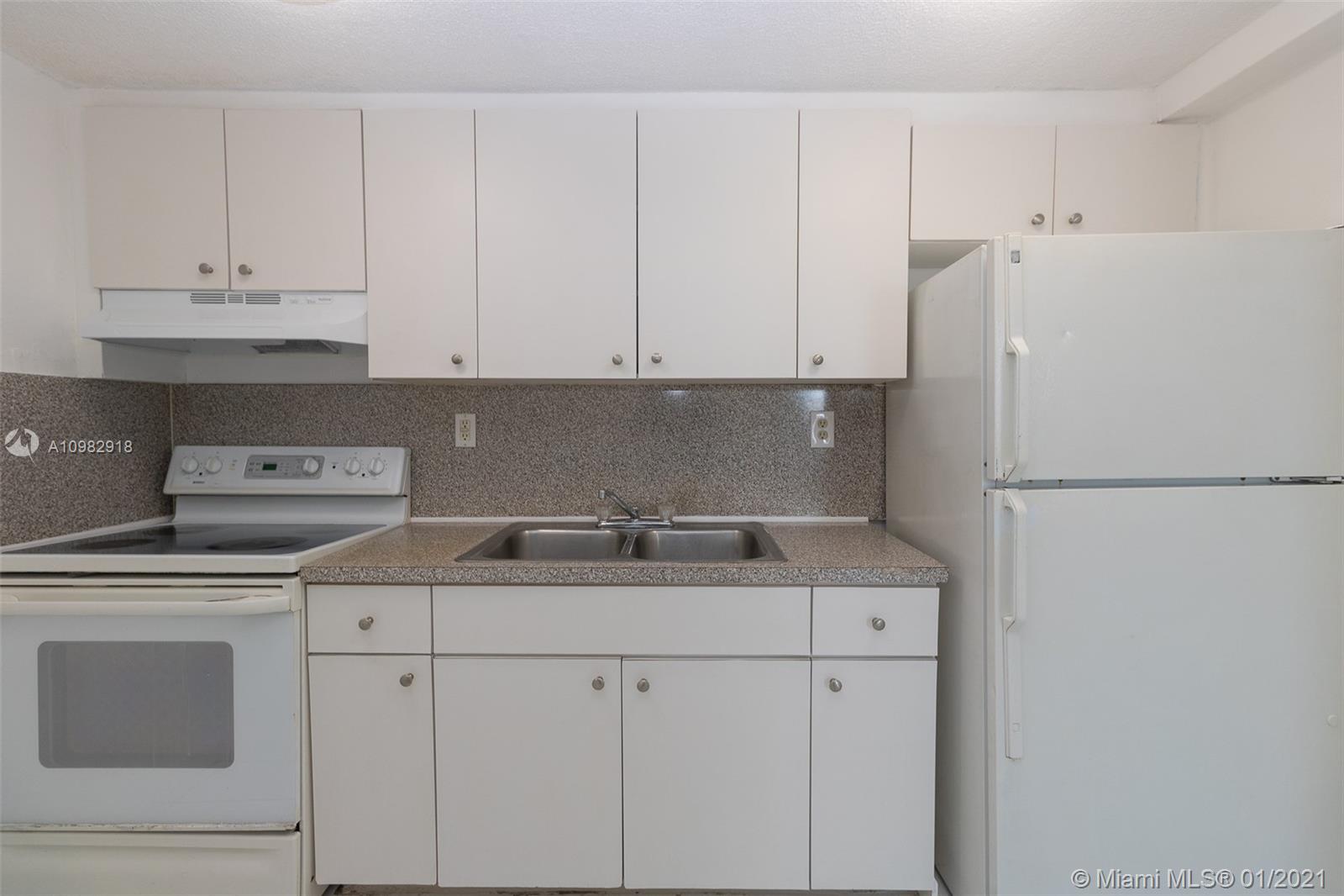 a kitchen with stainless steel appliances granite countertop white refrigerator stove and white cabinets