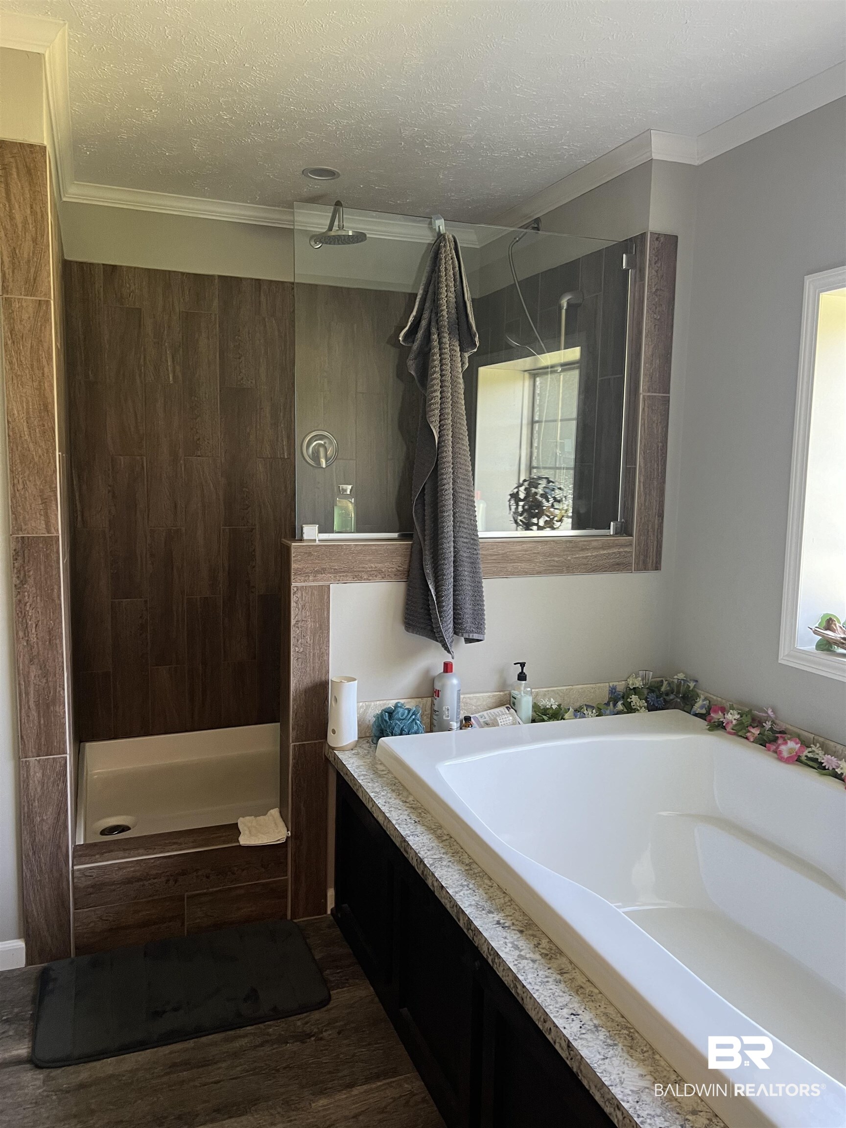 16824 Underwood Road Foley, AL 36535 - Photo 17 of 25 Bathroom with a textured ceiling, independent shower and bath, crown molding, and wood-type flooring