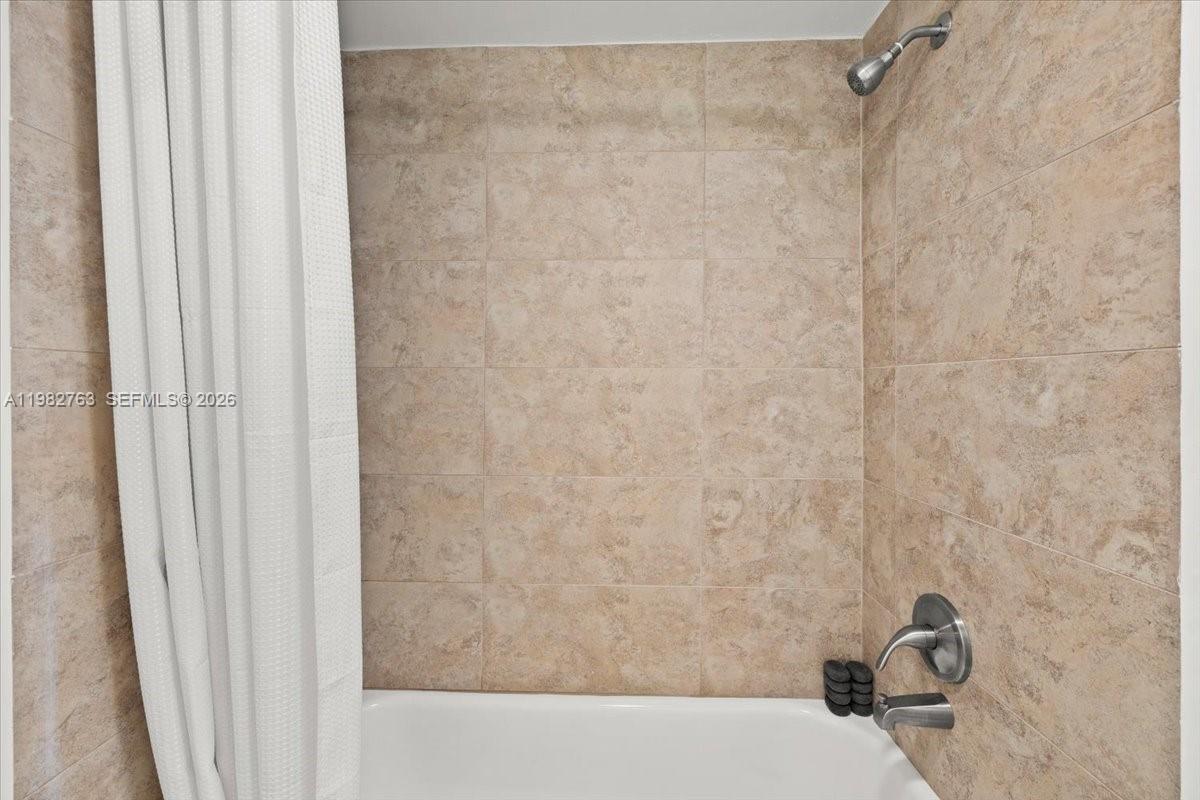 7944 Eastlake Drive, Unit D Boca Raton, FL 33433 - Photo 19 of 29 a bathroom with a shower curtain