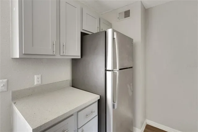 a kitchen with a refrigerator and cabinets