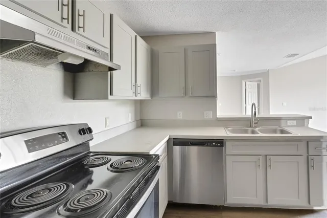 a kitchen with stainless steel appliances granite countertop a sink and a stove