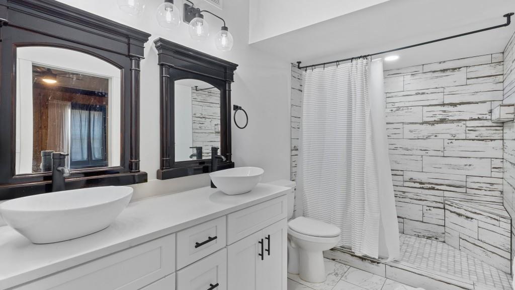 610 Madola Road, Unit 1 Epworth, GA 30541 - Photo 13 of 14 a bathroom with a granite countertop sink a toilet and a mirror