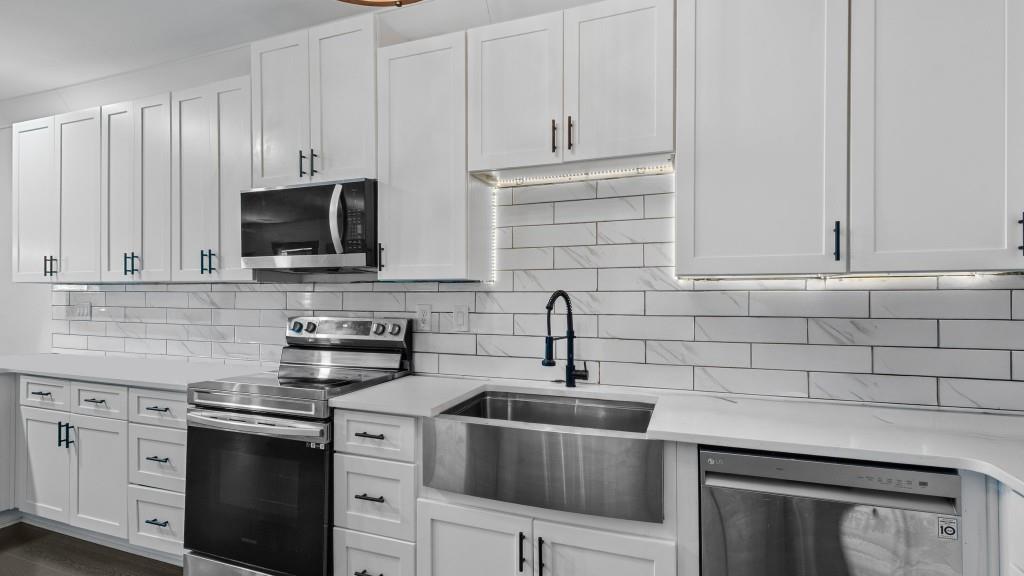 610 Madola Road, Unit 1 Epworth, GA 30541 - Photo 3 of 14 a kitchen with stainless steel appliances granite countertop white cabinets a sink a stove and dishwasher
