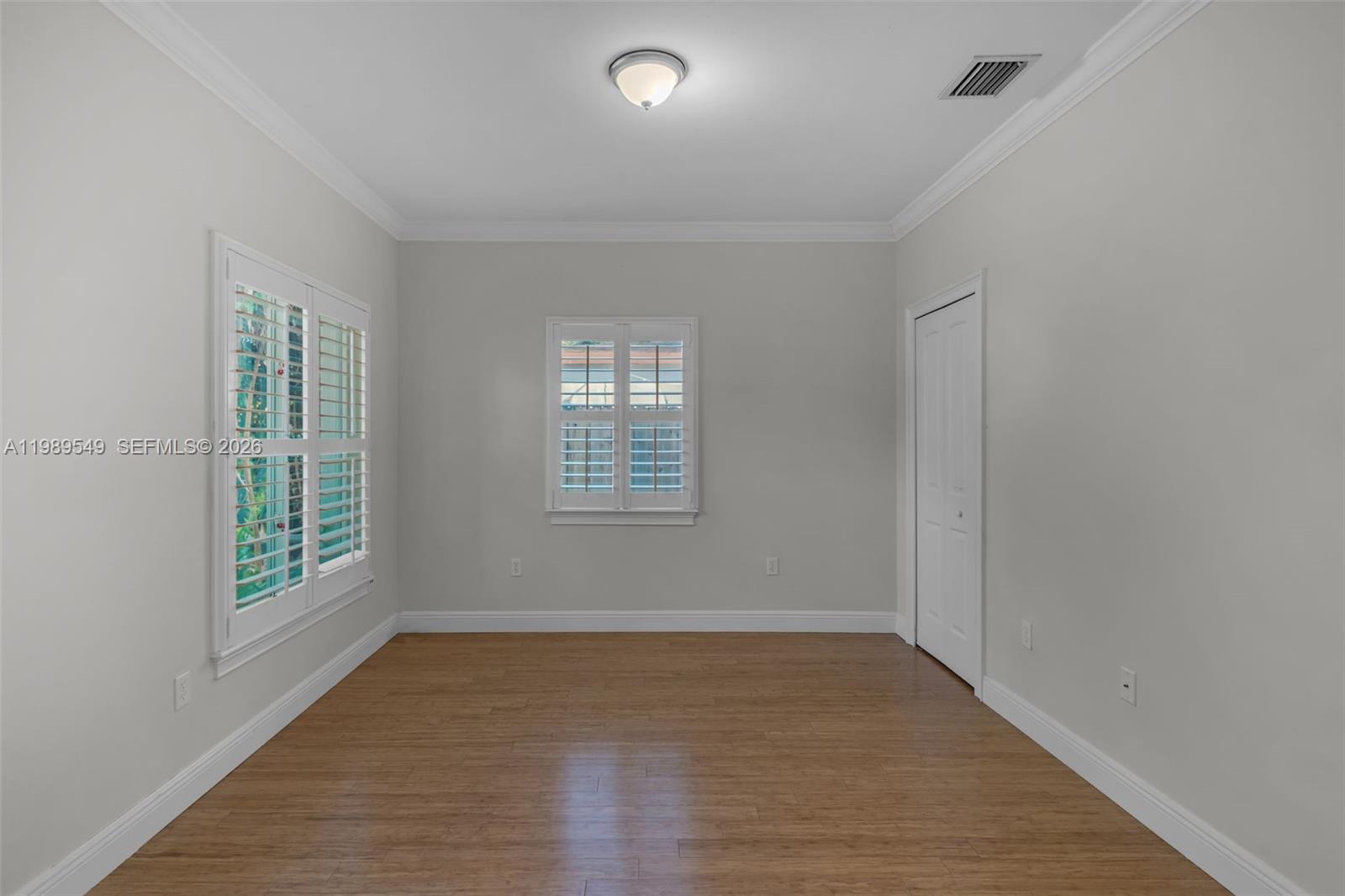 7048 Southwest 83rd Court Miami, FL 33143 - Photo 13 of 38 an empty room with wooden floor and windows