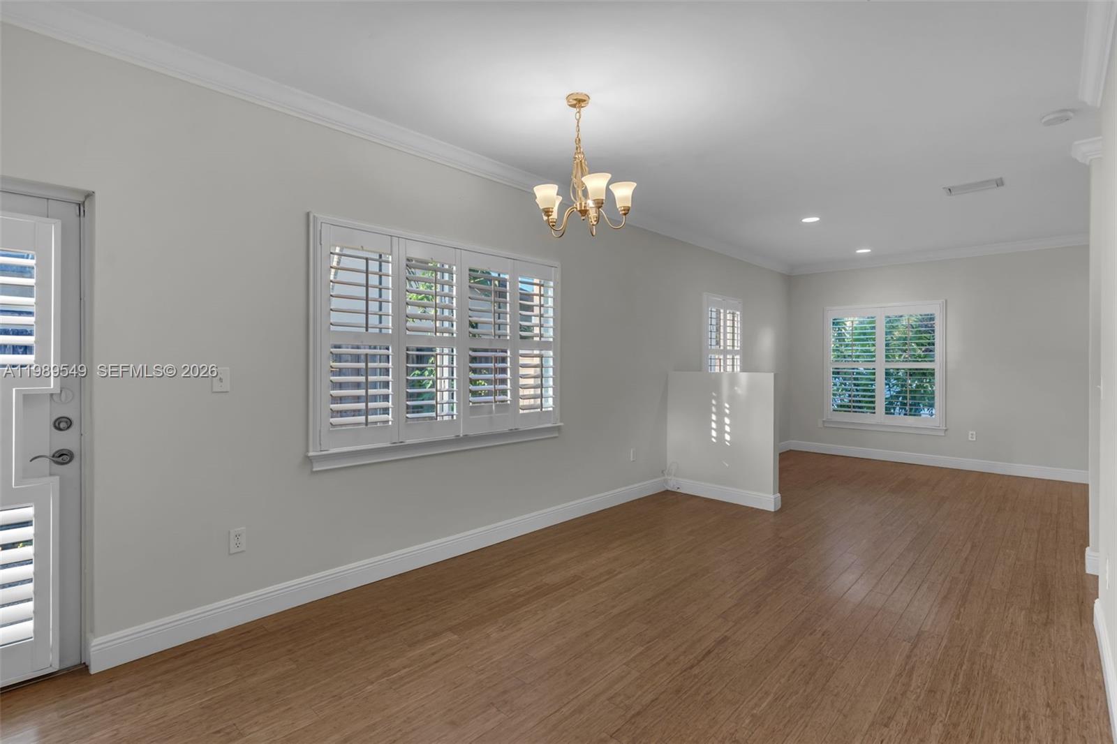 7048 Southwest 83rd Court Miami, FL 33143 - Photo 17 of 38 an empty room with wooden floor exposed radiator and windows