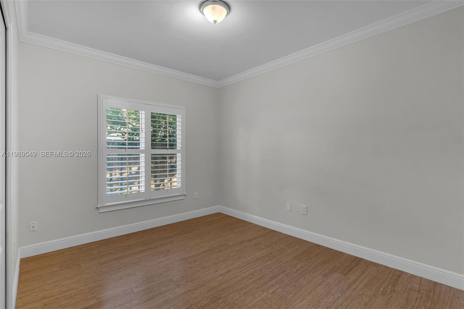 7048 Southwest 83rd Court Miami, FL 33143 - Photo 22 of 38 an empty room with wooden floor and windows