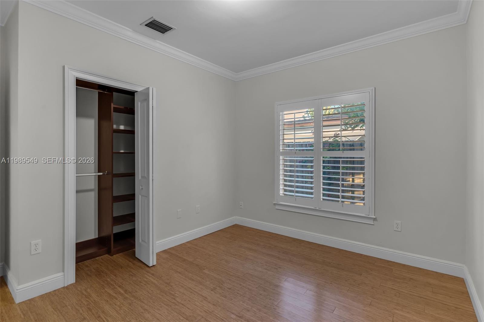 7048 Southwest 83rd Court Miami, FL 33143 - Photo 23 of 38 an empty room with wooden floor closet and windows