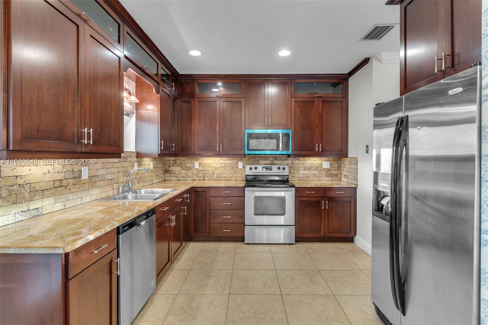 7048 Southwest 83rd Court Miami, FL 33143 - Photo 8 of 38 a large kitchen with a large counter top stainless steel appliances and cabinets