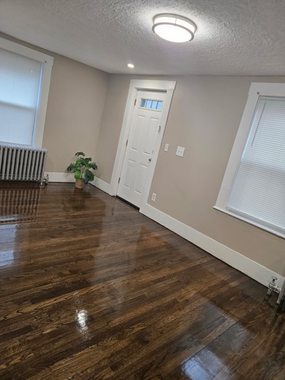 135 Guild Road Brockton, MA 02302 - Photo 2 of 12 an empty room with wooden floor and door