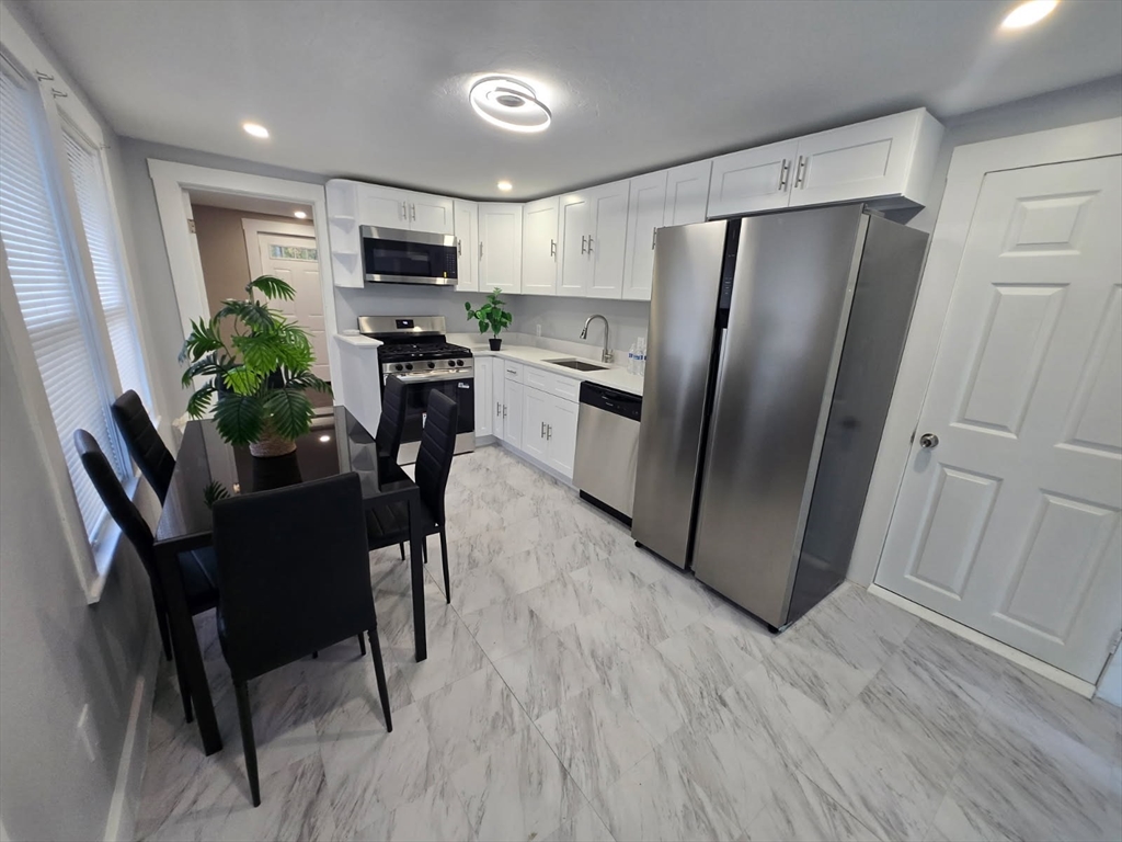 135 Guild Road Brockton, MA 02302 - Photo 5 of 12 a kitchen with stainless steel appliances a refrigerator a stove a microwave and dining table