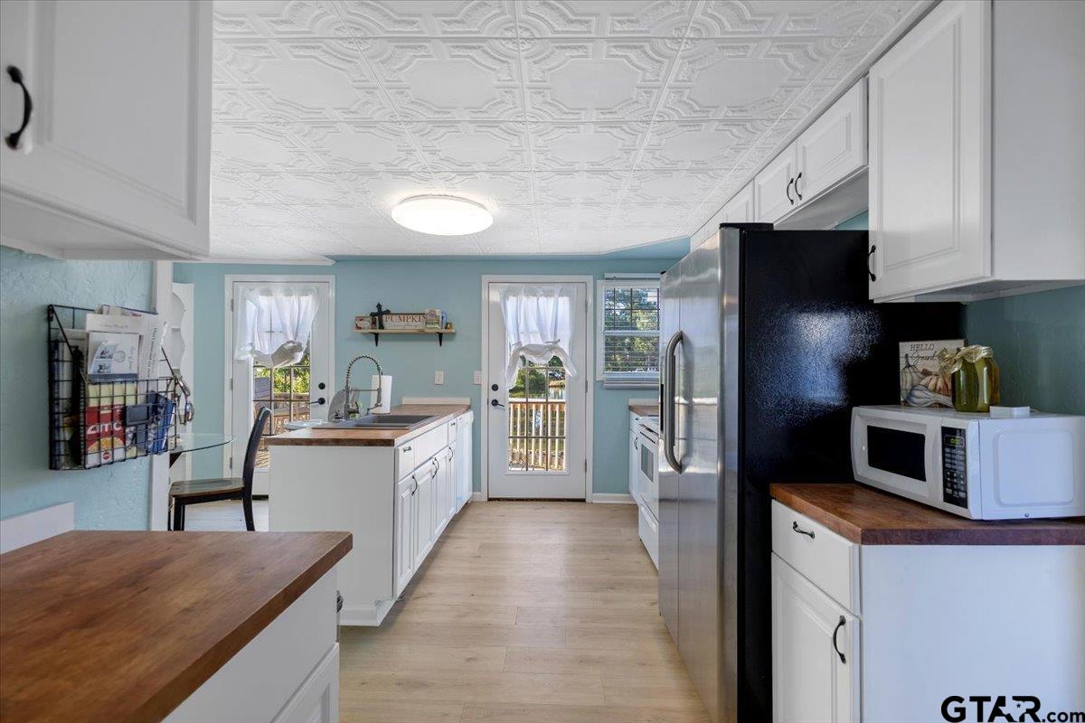 10286 US Highway 69 North Tyler, TX 75706 - Photo 22 of 31 a kitchen with stainless steel appliances granite countertop a refrigerator a stove and a sink with wooden floors