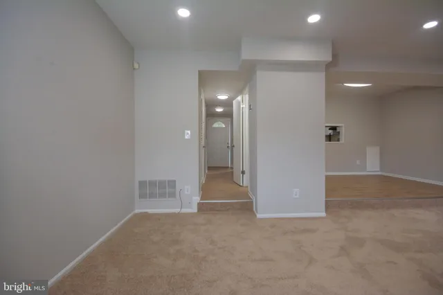 a view of an empty room with closet and bathroom