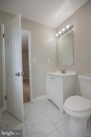 a bathroom with a toilet a sink and mirror