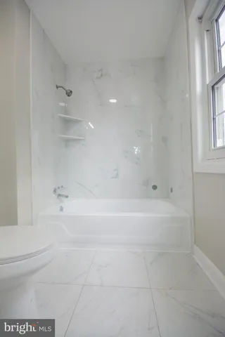 a bathroom with a bathtub shower sink and a toilet