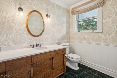 a bathroom with a granite countertop toilet a sink and a mirror