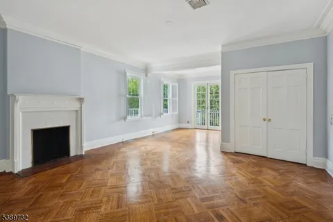 a view of empty room with wooden floor and fireplace