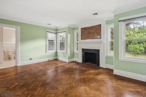 a view of an empty room with window and fire place