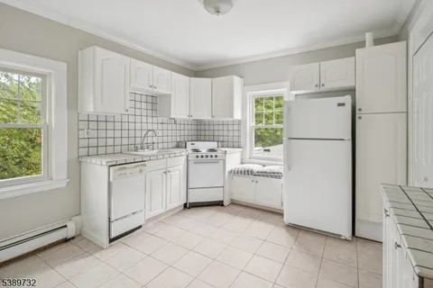 a kitchen with white cabinets and white appliances