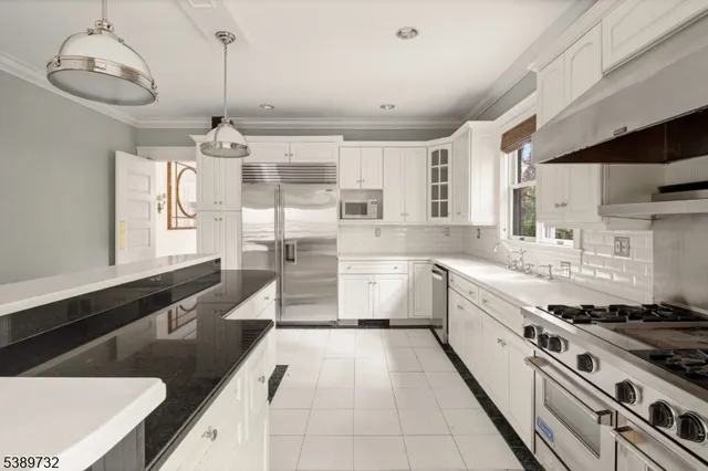 a large kitchen with stainless steel appliances granite countertop a sink and cabinets