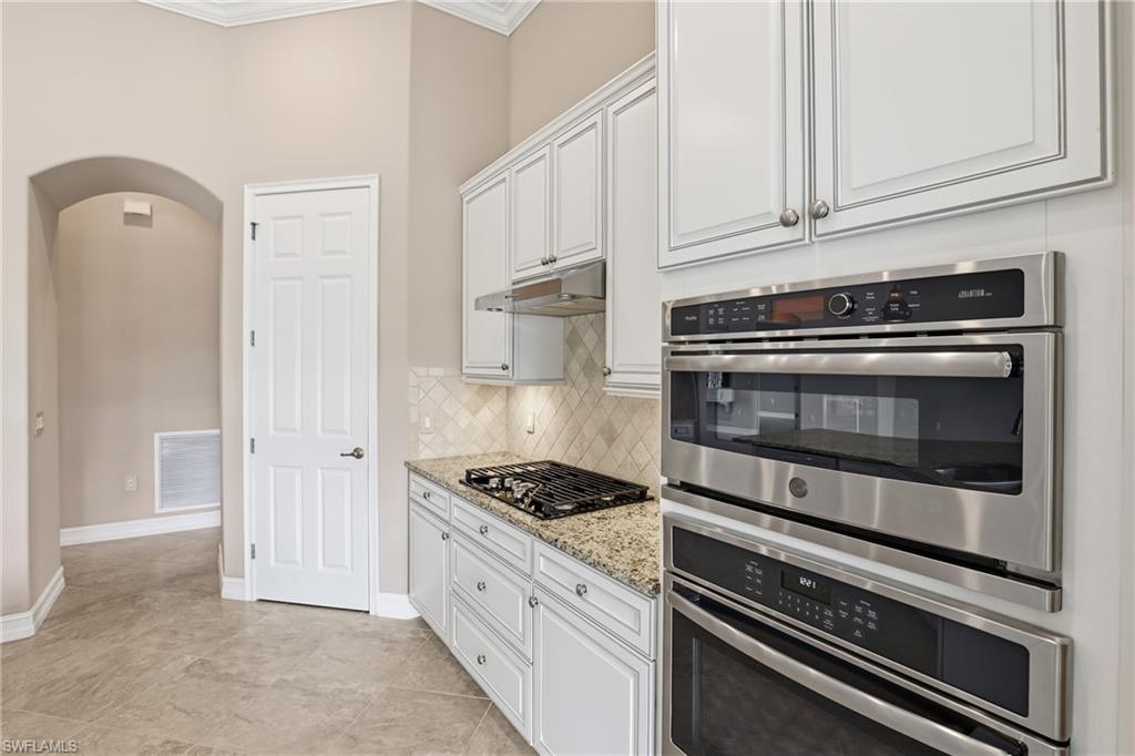 2280 Somerset Place Naples, FL 34120 - Photo 16 of 49 a kitchen with granite countertop cabinets and steel stainless steel appliances