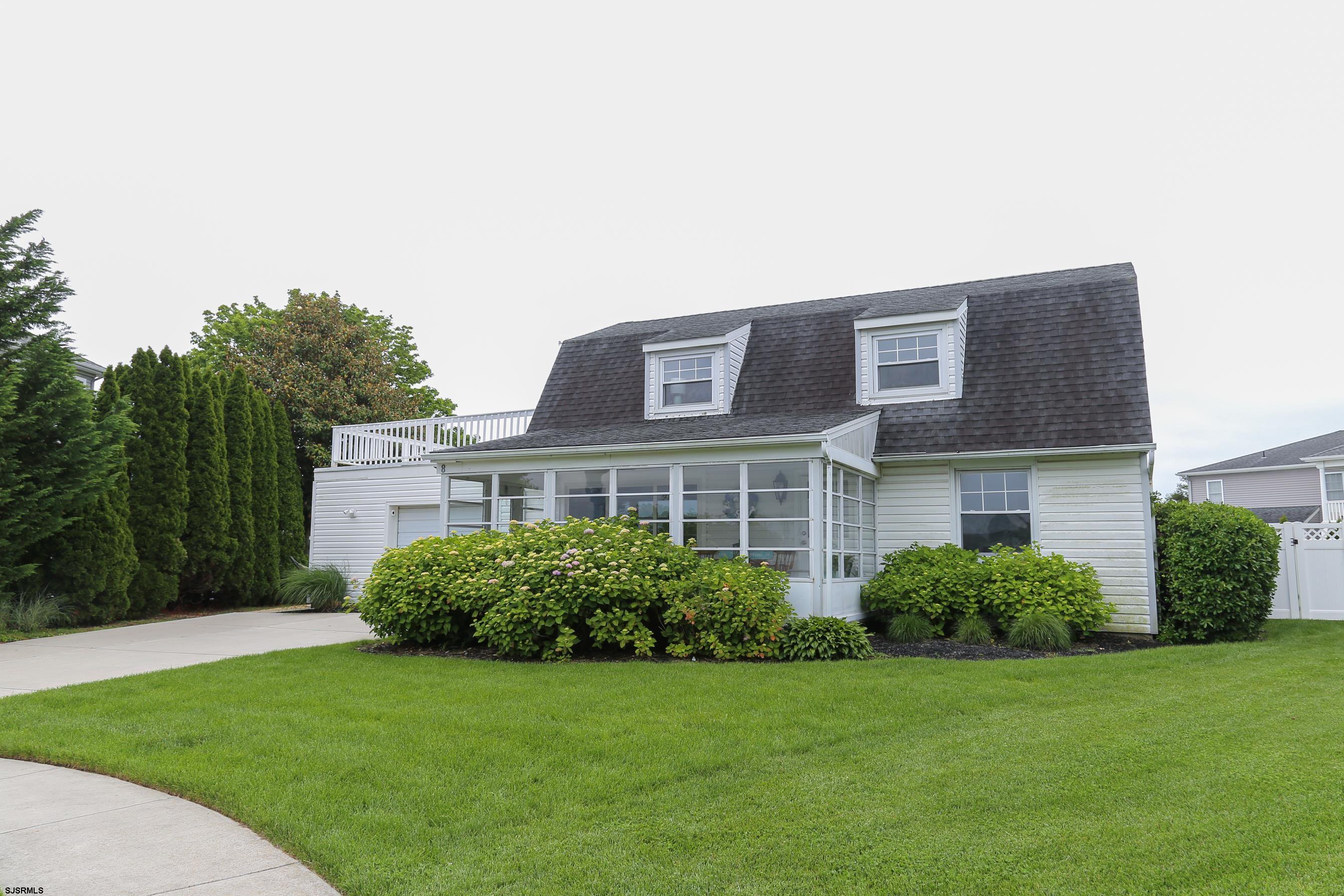 a house that is sitting in the grass with large trees