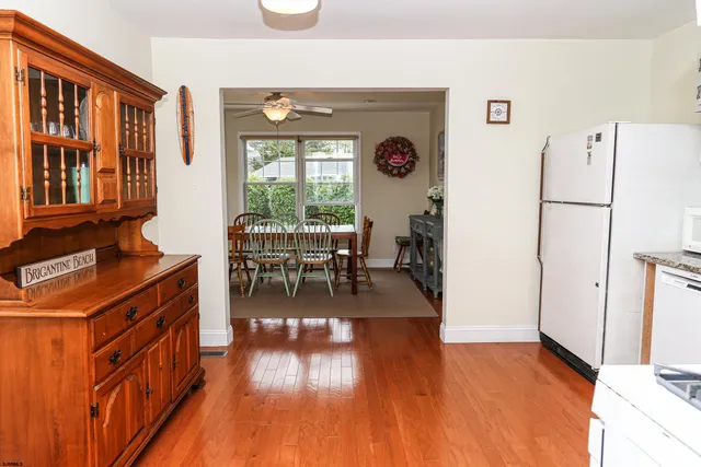 a view of a dining room with furniture a fire place and wooden floor