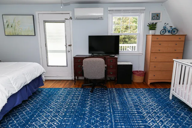 a bedroom with a bed wooden floor and window