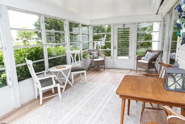 a living room with furniture a large window and dining table