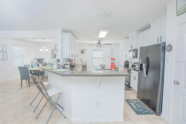 a large kitchen with kitchen island a sink a stove a dining table and chairs
