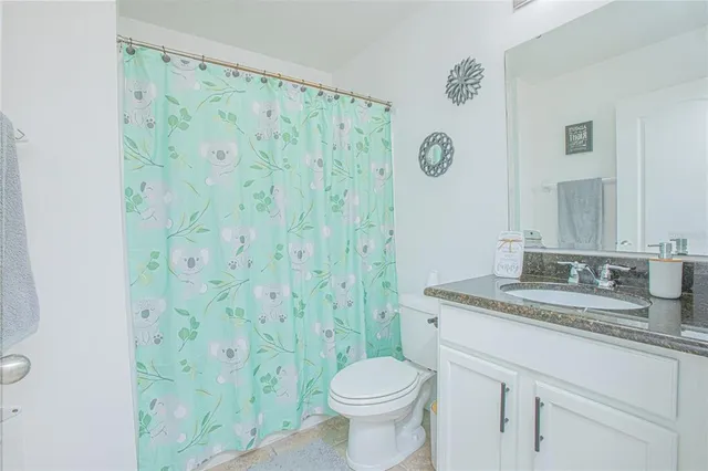 a bedroom with a bed potted plant on the dresser and a chandelier
