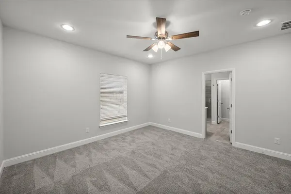 an empty room with windows and fan