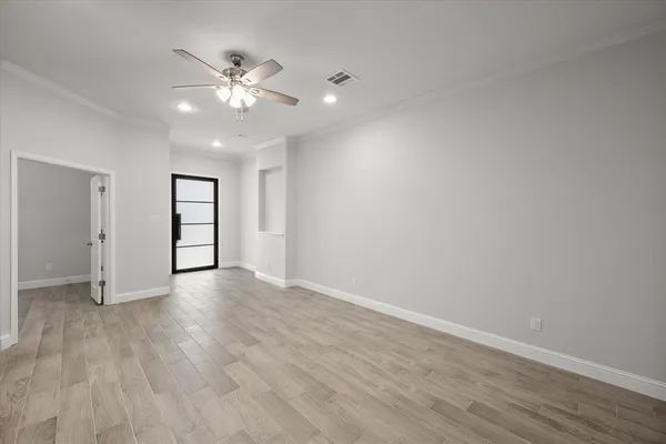 a view of an empty room with wooden floor