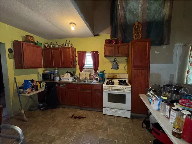 a kitchen with a stove a refrigerator and wooden cabinets