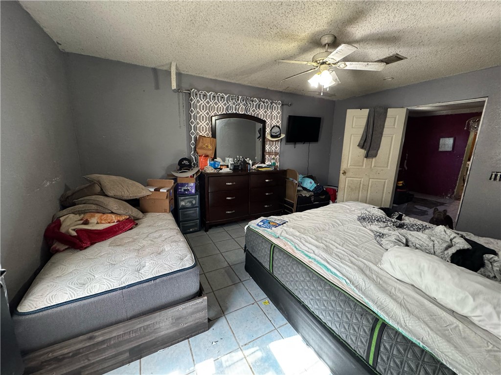 122 West 5th Street Alice, TX 78332 - Photo 40 of 40 a bedroom with a bed and a chandelier