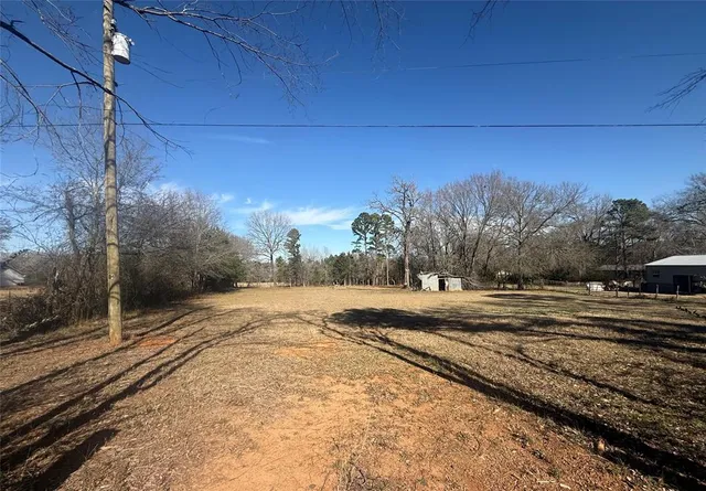 a view of a yard with wooden fence